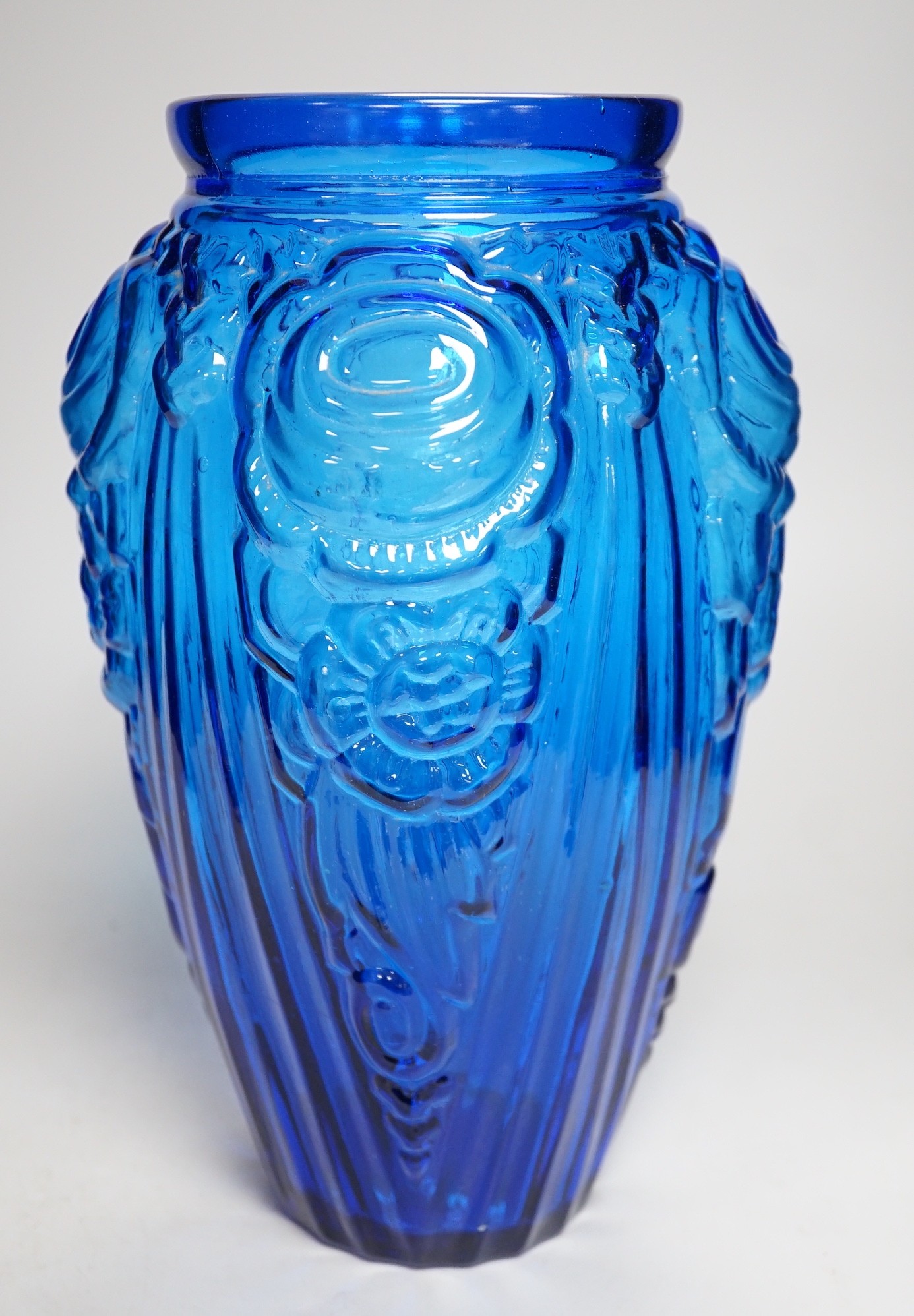 An Art Deco blue floral moulded glass vase. 31cm tall
